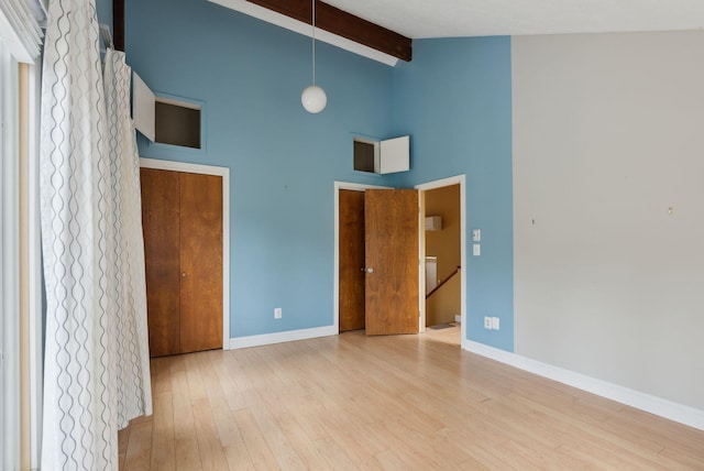 12 Bufflehead Cove Ln, Kennebunk, ME 04043 - unfurnished bedroom with beam ceiling, wood finished floors, baseboards, and high vaulted ceiling