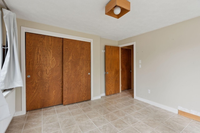 12 Bufflehead Cove Ln, Kennebunk, ME 04043 - unfurnished bedroom with light tile patterned floors, baseboards, and a closet