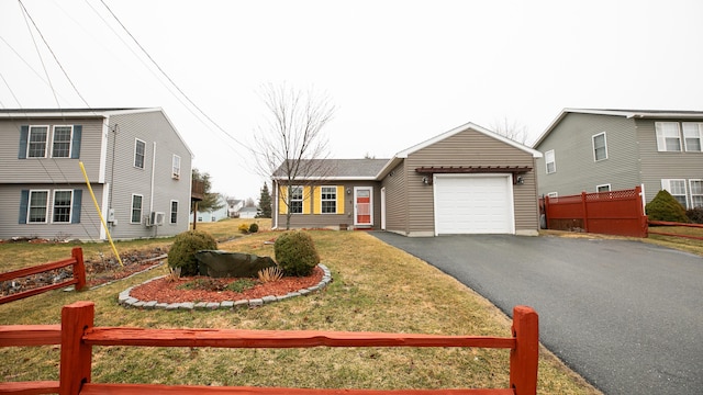 view of front of house featuring an attached garage, driveway, fence, and a front lawn