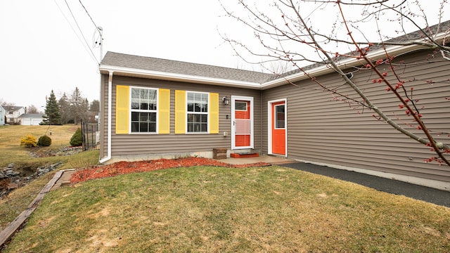 view of front of home with entry steps and a front lawn