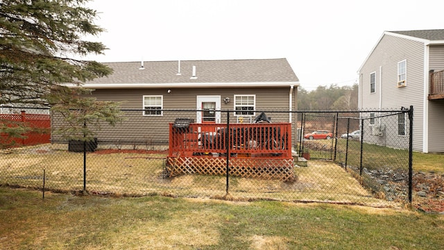 rear view of house featuring a yard, fence, a shingled roof, and a wooden deck