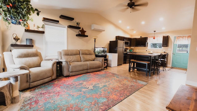 living area with ceiling fan, light wood-style floors, recessed lighting, a wall unit AC, and lofted ceiling
