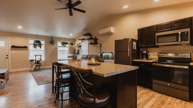 kitchen with stainless steel appliances, light wood-type flooring, a center island, and a breakfast bar area