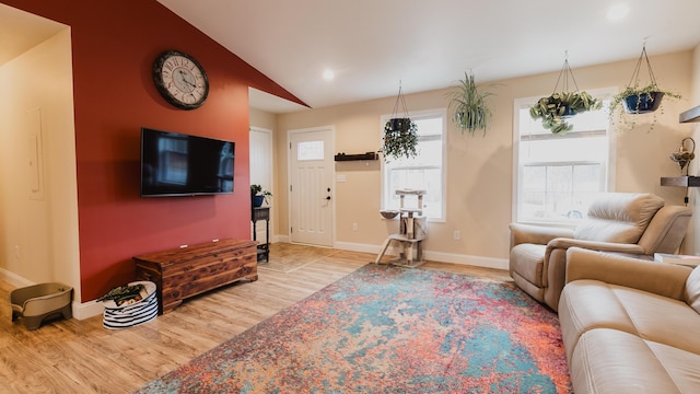 living room featuring baseboards, vaulted ceiling, and wood finished floors