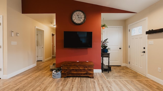 entrance foyer with baseboards, vaulted ceiling, and wood finished floors