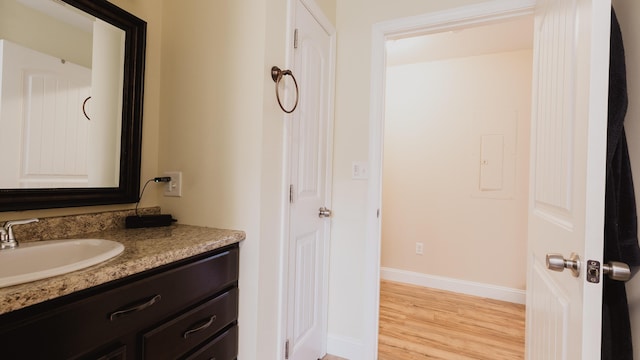bathroom featuring baseboards, vanity, and wood finished floors