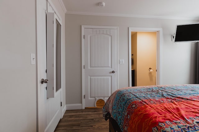 bedroom with baseboards, crown molding, and wood finished floors