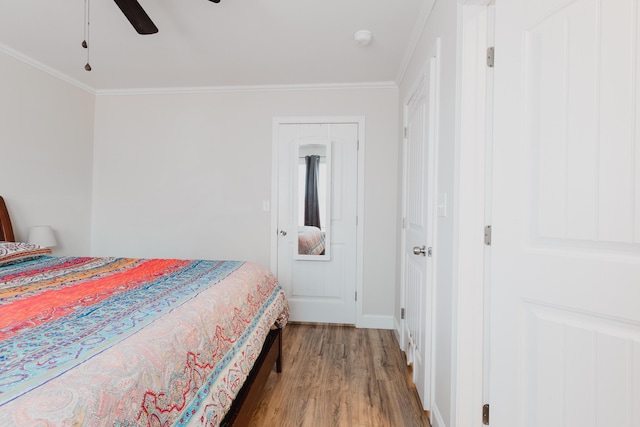 bedroom featuring ornamental molding, baseboards, a ceiling fan, and wood finished floors