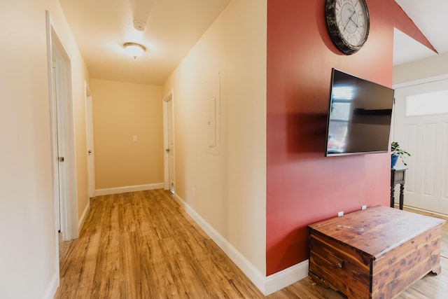 corridor with baseboards and wood finished floors