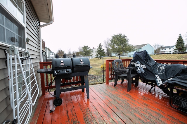 wooden deck featuring fence and a grill