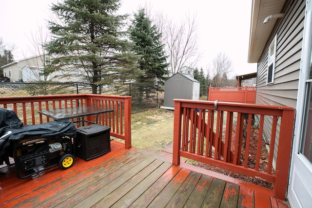 wooden deck with a shed, fence, and an outdoor structure