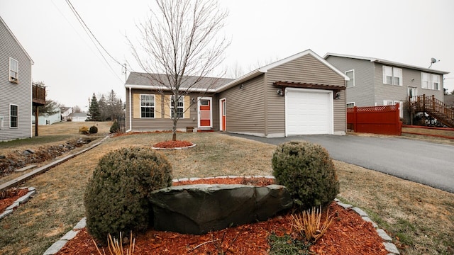 ranch-style house featuring a garage and aphalt driveway
