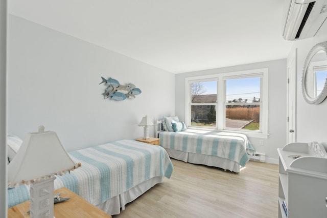 bedroom with an AC wall unit, light wood-type flooring, and a baseboard radiator