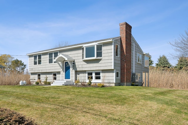 raised ranch featuring a chimney and a front yard
