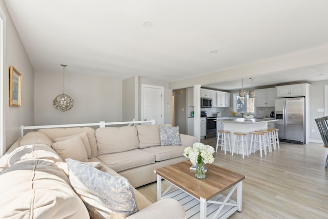 living area with baseboards and light wood finished floors