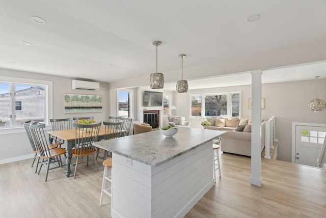 kitchen with light wood-style floors, plenty of natural light, and a breakfast bar