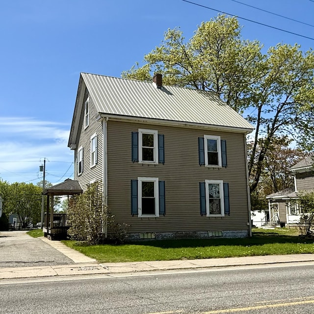 68 Washington St, Eastport, ME 04631 - view of home's exterior with a chimney, metal roof, and a yard