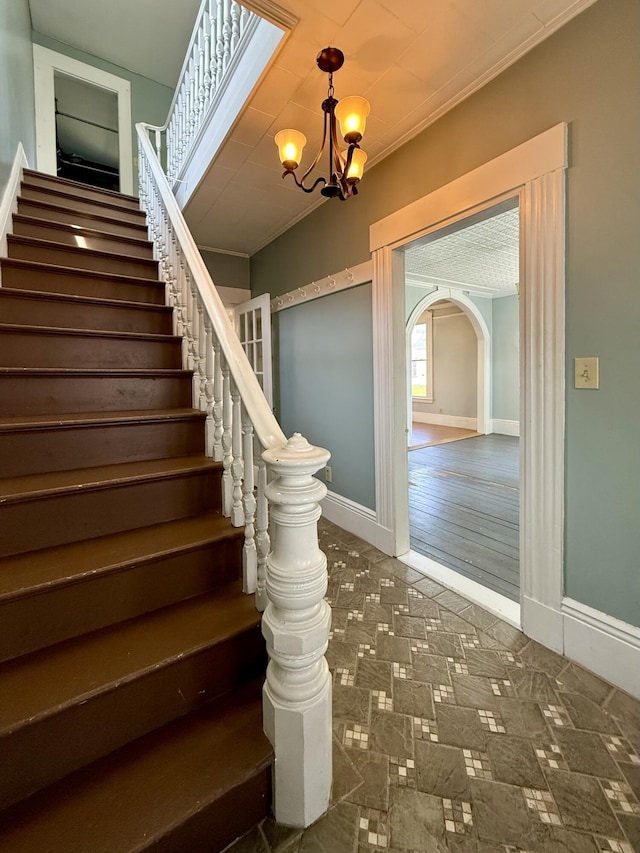 68 Washington St, Eastport, ME 04631 - stairs with ornamental molding, a chandelier, baseboards, and arched walkways