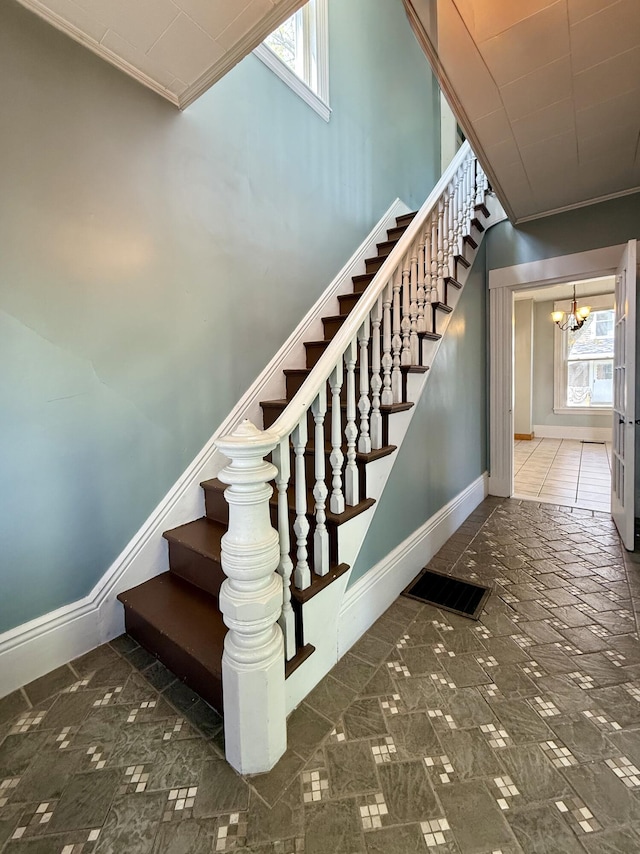 68 Washington St, Eastport, ME 04631 - staircase with crown molding, baseboards, plenty of natural light, and a chandelier