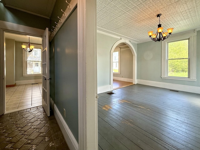 68 Washington St, Eastport, ME 04631 - hallway featuring a chandelier, crown molding, arched walkways, baseboards, and hardwood / wood-style flooring