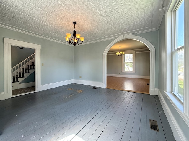 68 Washington St, Eastport, ME 04631 - empty room featuring a chandelier, arched walkways, hardwood / wood-style floors, crown molding, and stairs