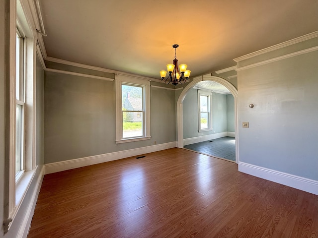 68 Washington St, Eastport, ME 04631 - unfurnished dining area featuring arched walkways, ornamental molding, a chandelier, baseboards, and wood finished floors
