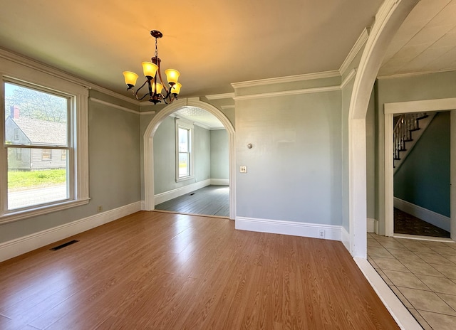 68 Washington St, Eastport, ME 04631 - unfurnished dining area featuring crown molding, arched walkways, a chandelier, plenty of natural light, and wood finished floors