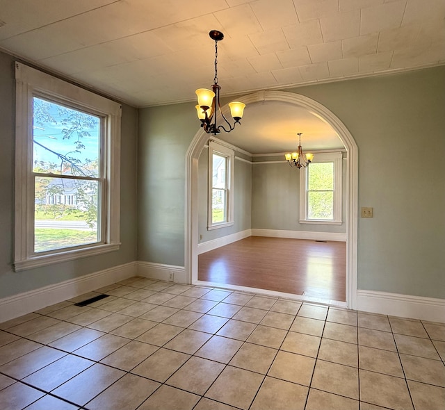 68 Washington St, Eastport, ME 04631 - unfurnished dining area featuring a chandelier, light tile patterned floors, baseboards, and arched walkways
