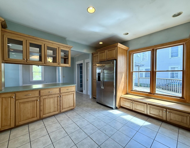 68 Washington St, Eastport, ME 04631 - kitchen featuring stainless steel fridge, glass insert cabinets, recessed lighting, brown cabinetry, and light tile patterned flooring