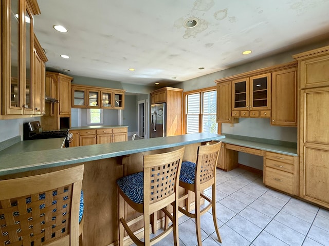 68 Washington St, Eastport, ME 04631 - kitchen featuring appliances with stainless steel finishes, a breakfast bar, a peninsula, recessed lighting, and glass insert cabinets