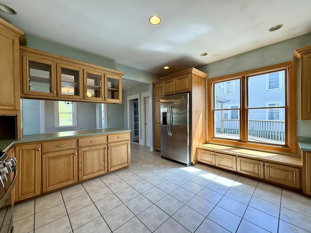 68 Washington St, Eastport, ME 04631 - kitchen with stainless steel fridge with ice dispenser, a peninsula, glass insert cabinets, light tile patterned floors, and recessed lighting