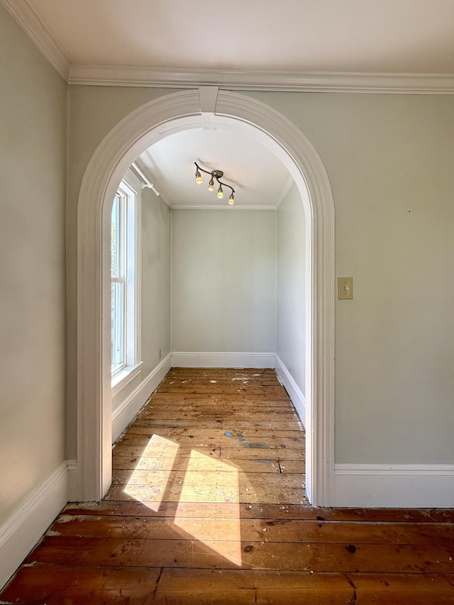 68 Washington St, Eastport, ME 04631 - unfurnished dining area with wood-type flooring, arched walkways, ornamental molding, and baseboards