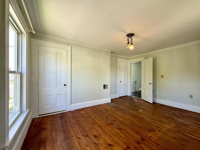 68 Washington St, Eastport, ME 04631 - unfurnished bedroom with dark wood finished floors, baseboards, and crown molding