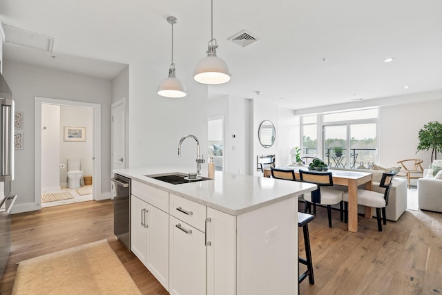 267 US Route 1 Ph 508, Falmouth, ME 04105 - kitchen featuring dishwasher, a sink, open floor plan, a kitchen island with sink, and white cabinetry