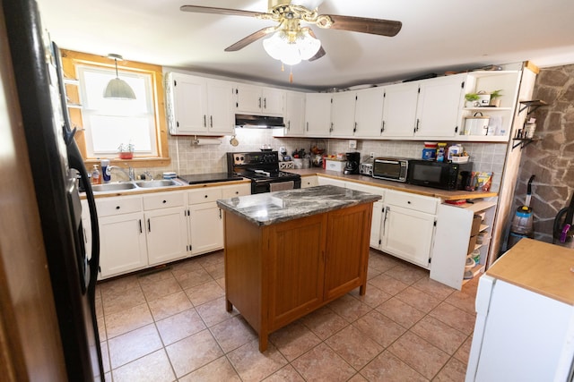kitchen featuring a sink, white cabinets, black appliances, backsplash, and under cabinet range hood