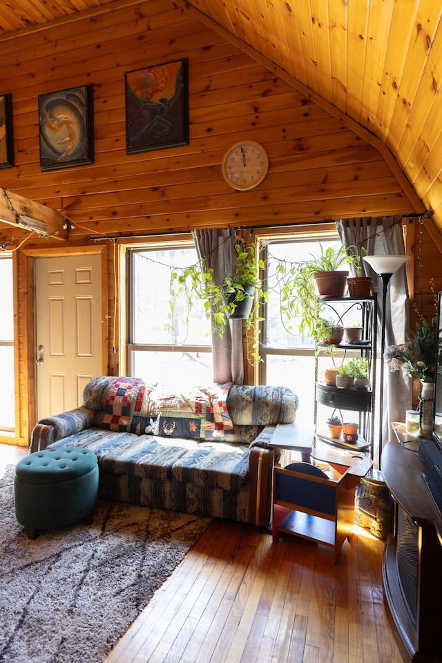 living area featuring wood-type flooring, vaulted ceiling, and wooden ceiling