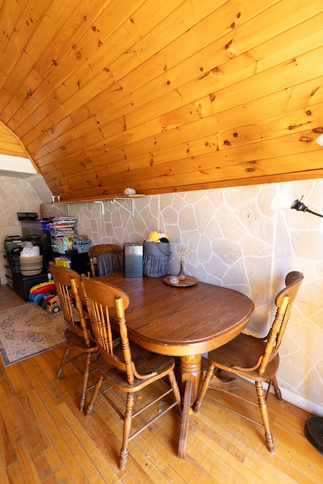 dining room featuring vaulted ceiling, light wood finished floors, and wood ceiling