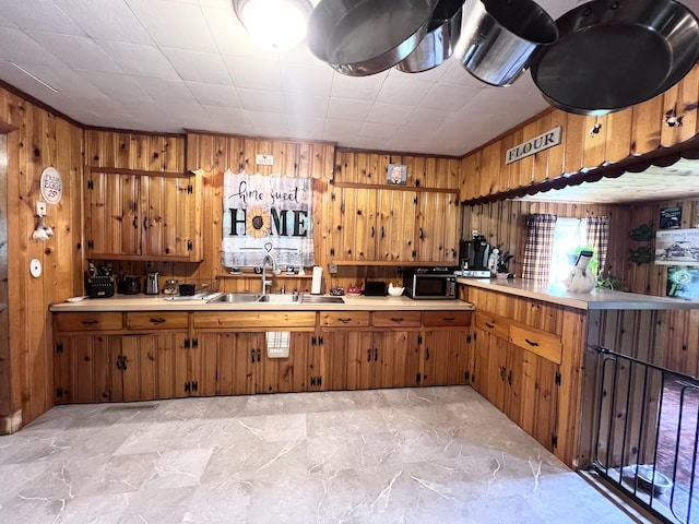 113 River Rd, Dresden, ME 04342 - kitchen with wooden walls, brown cabinetry, light countertops, and ornamental molding