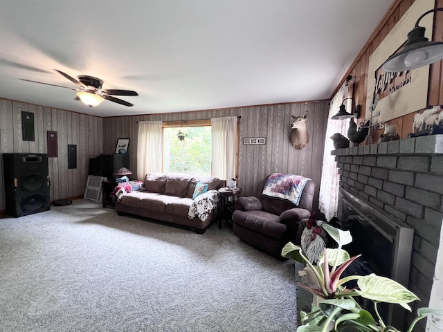 113 River Rd, Dresden, ME 04342 - carpeted living room featuring ceiling fan, electric panel, wood walls, and a brick fireplace