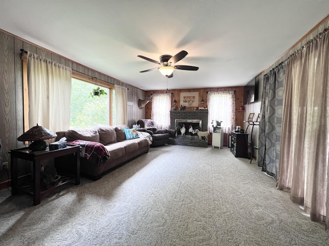 113 River Rd, Dresden, ME 04342 - living room featuring light carpet, ceiling fan, a brick fireplace, and wooden walls
