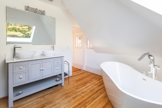 26 Old Searsport Ave, Belfast, ME 04915 - full bath with double vanity, a sink, a freestanding tub, and wood finished floors