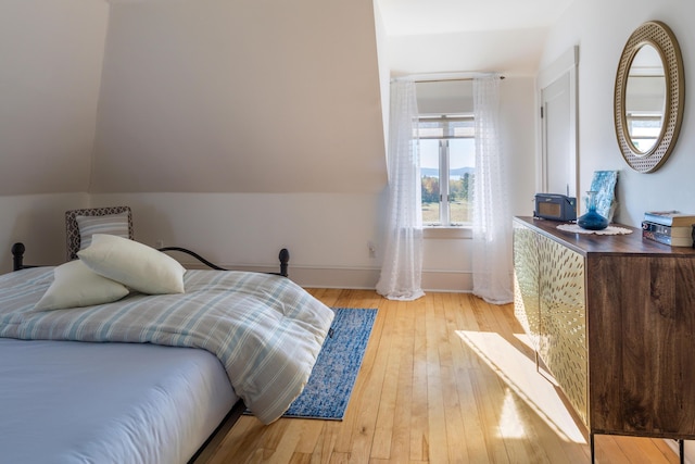 26 Old Searsport Ave, Belfast, ME 04915 - bedroom featuring baseboards, vaulted ceiling, and light wood-style flooring