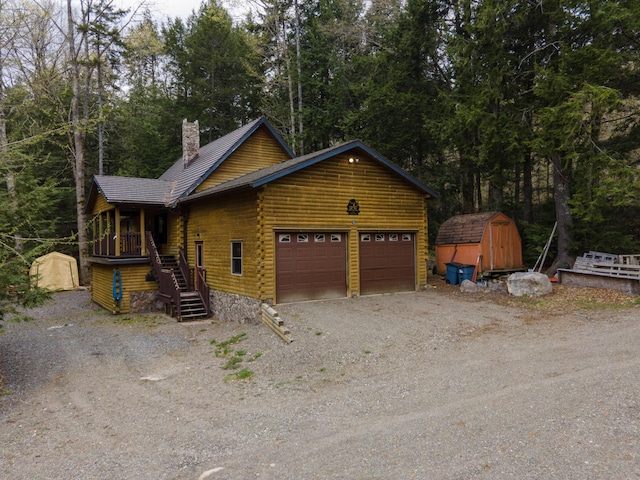 5 Canoe Ct Unit T3 R9, Nwp, ME 04462 - view of front of home with a storage shed, log siding, an attached garage, a chimney, and stairway