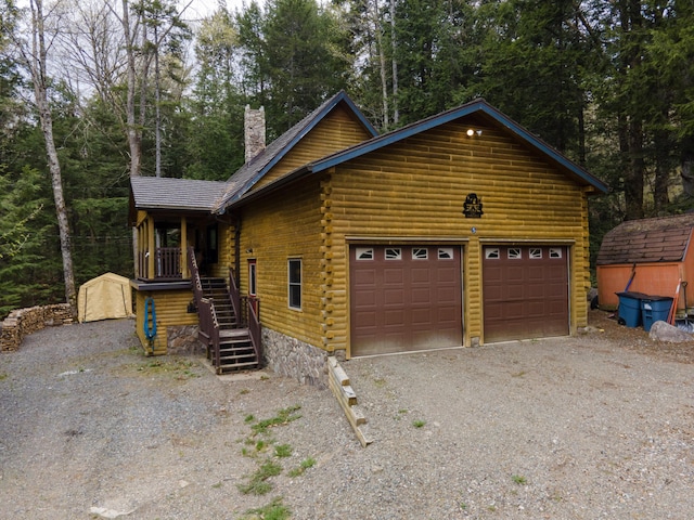 5 Canoe Ct Unit T3 R9, Nwp, ME 04462 - cabin with log exterior, a chimney, a garage, stairs, and view of scattered trees