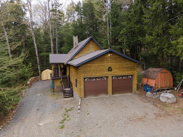 5 Canoe Ct Unit T3 R9, Nwp, ME 04462 - view of front facade with a shed, a chimney, driveway, log siding, and an outbuilding