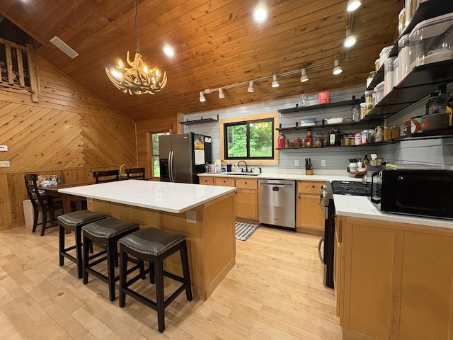 5 Canoe Ct Unit T3 R9, Nwp, ME 04462 - kitchen with stainless steel appliances, track lighting, light wood-style flooring, a chandelier, and wood walls
