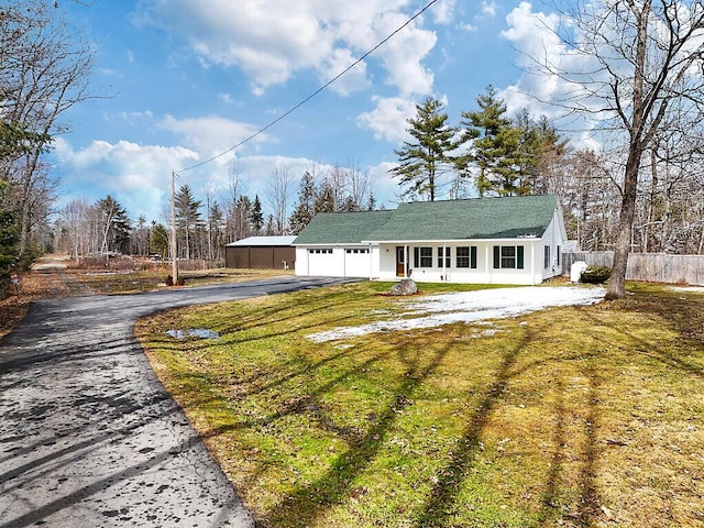 view of front facade with a front yard, an attached garage, fence, and driveway