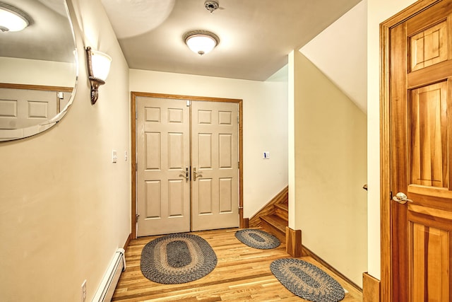 entrance foyer featuring baseboard heating, baseboards, and light wood finished floors