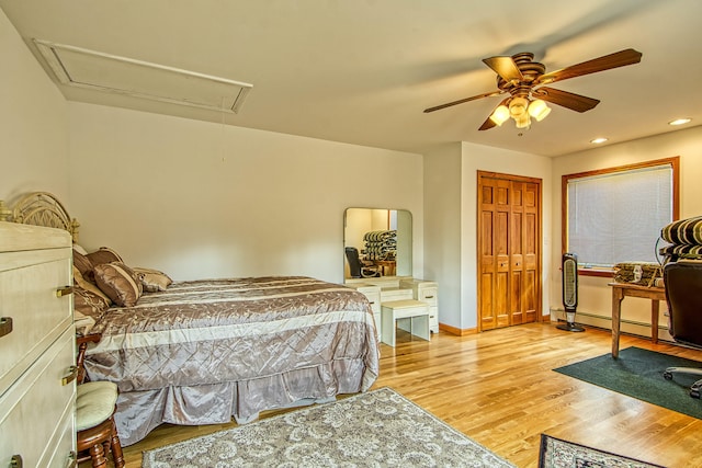 bedroom with a baseboard radiator, light wood-style floors, baseboards, attic access, and recessed lighting