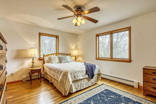 bedroom with a baseboard radiator, ceiling fan, light wood finished floors, and baseboards